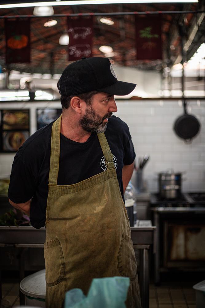 Retrato de Luiz Campiglia de boné e avental na cozinha